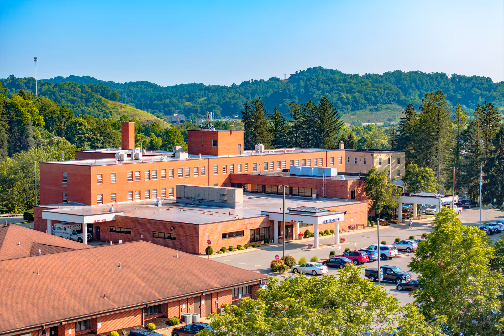 Exterior of St Joseph's Hospital building with a parking lot and surrounding trees.