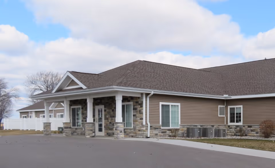 One-story assisted living facility exterior with a covered entrance and stone facade.