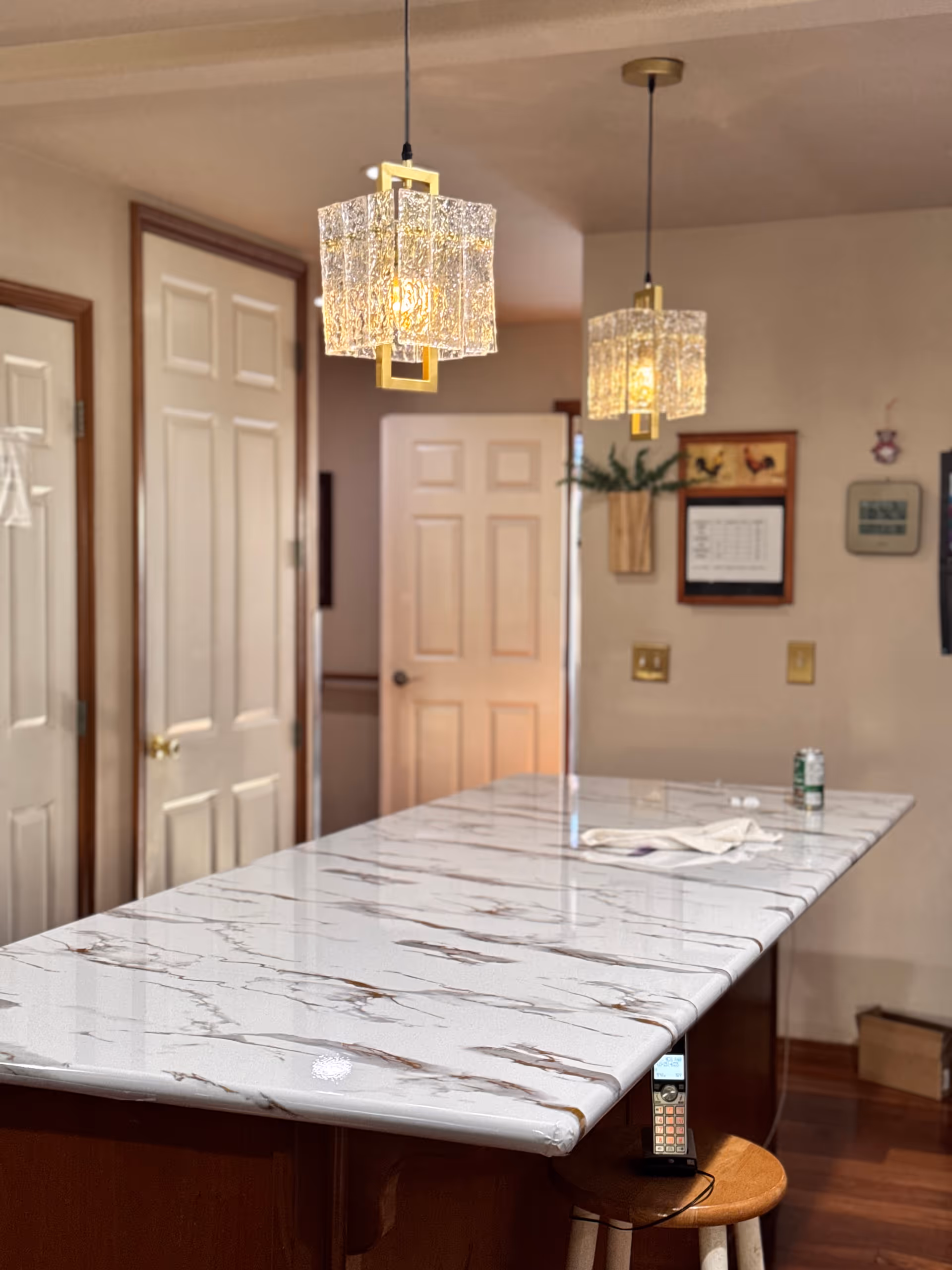 Marble-topped kitchen island with pendant lights in a senior living facility.