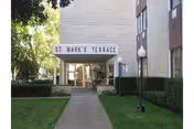 Front entrance of St. Mark's Terrace with a walkway and hedges.