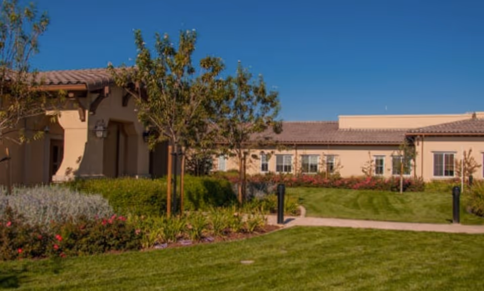 A single-story Creekview Health Center building with landscaped lawn and pathway in front.