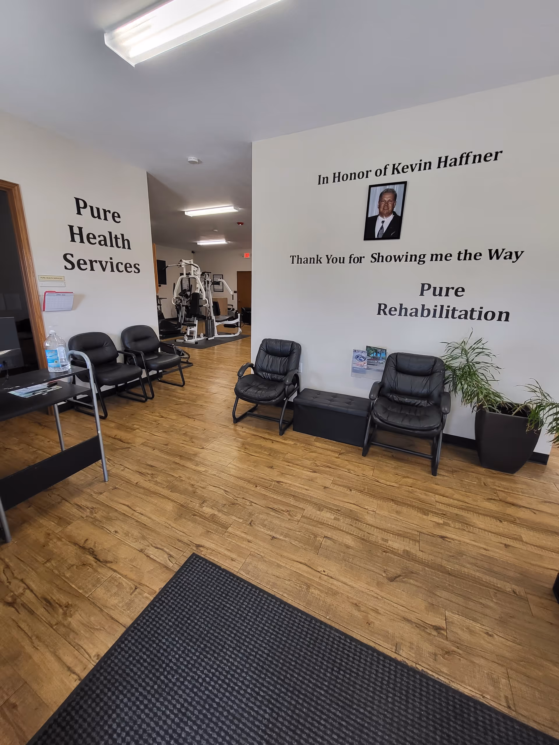 Interior lobby of Pure Health Services with seating and visible exercise equipment.