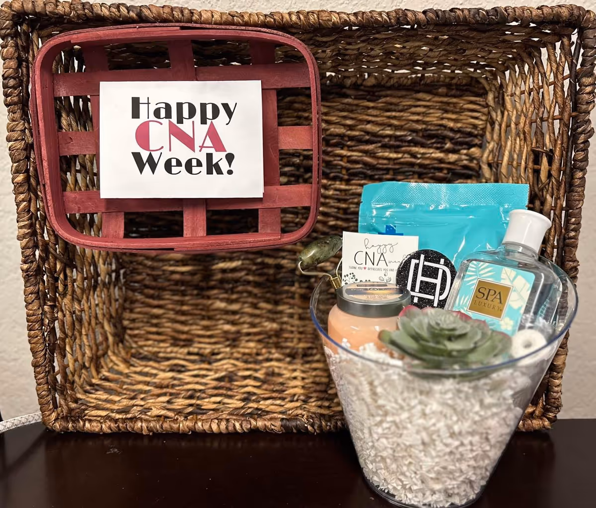 A woven basket sits on a table with spa items and a CNA Week card.
