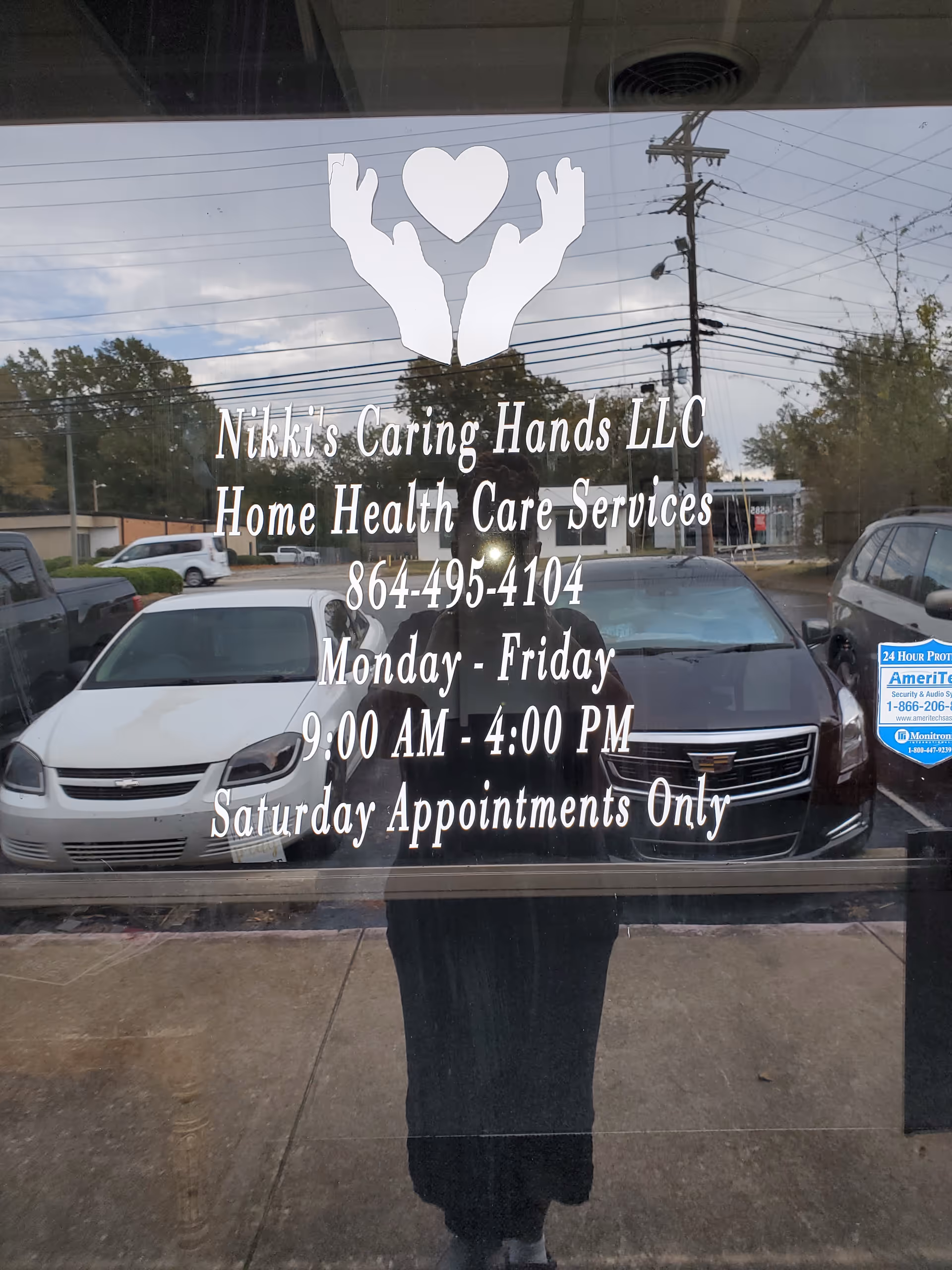 Storefront window for Nikki's Caring Hands LLC displays hours, contact info, and services.