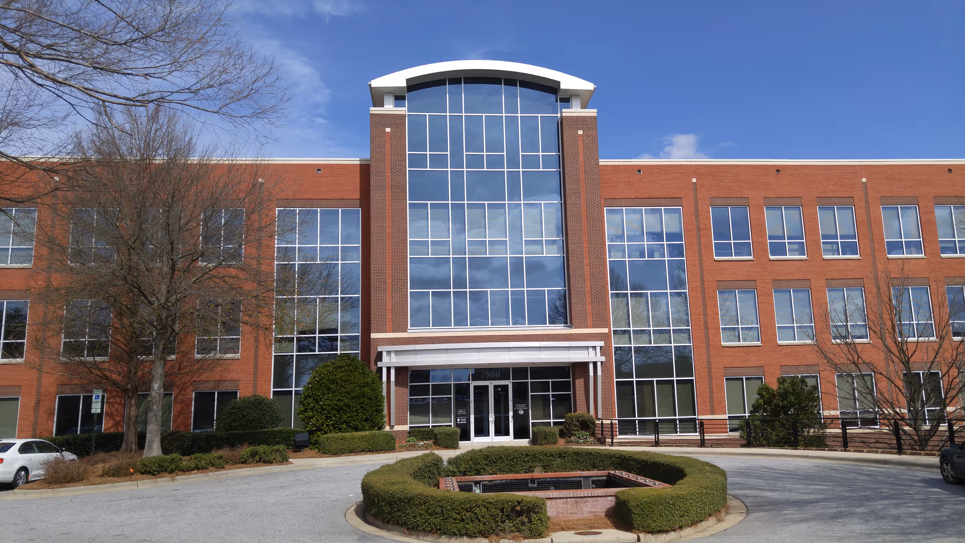 Exterior view of SunCrest Home Health Greensboro building with glass entrance and landscaping.
