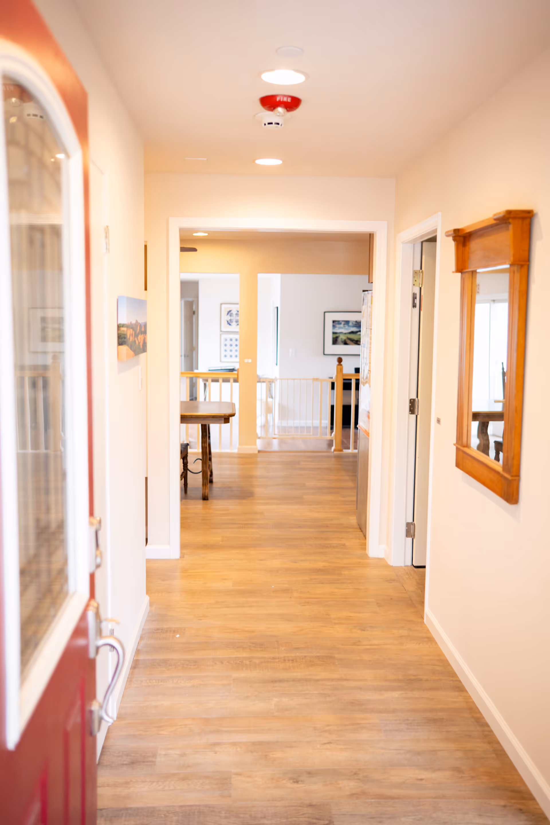 Bright wooden hallway inside Sonoma County Care Home with doors and a railing.