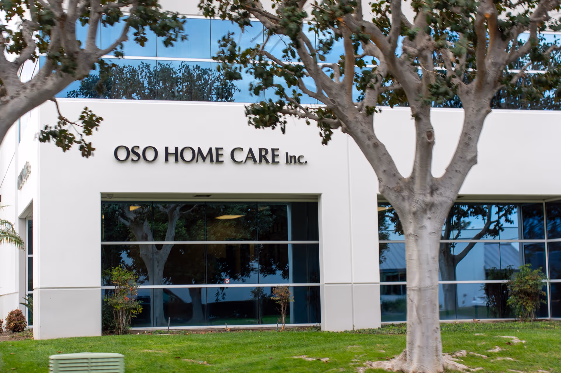 OSO Home Care Inc. building exterior with large glass windows and trees
