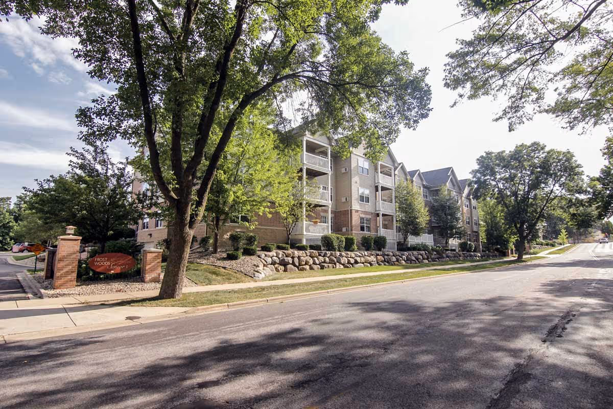 Exterior view of Frost Woods I and II with trees, sidewalk, and a multi-story building