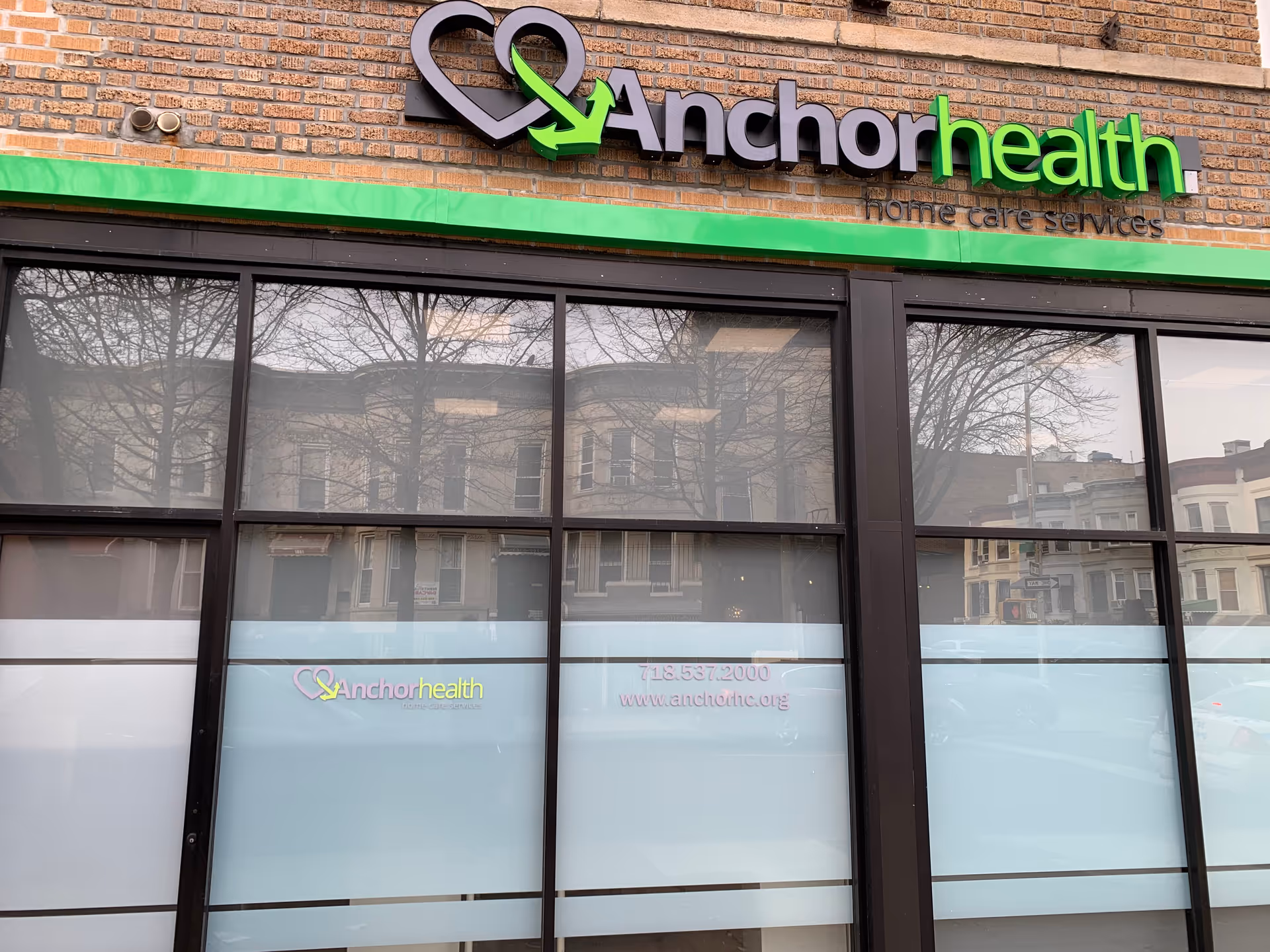 Brick building facade with Anchor Health signage and large glass storefront windows.