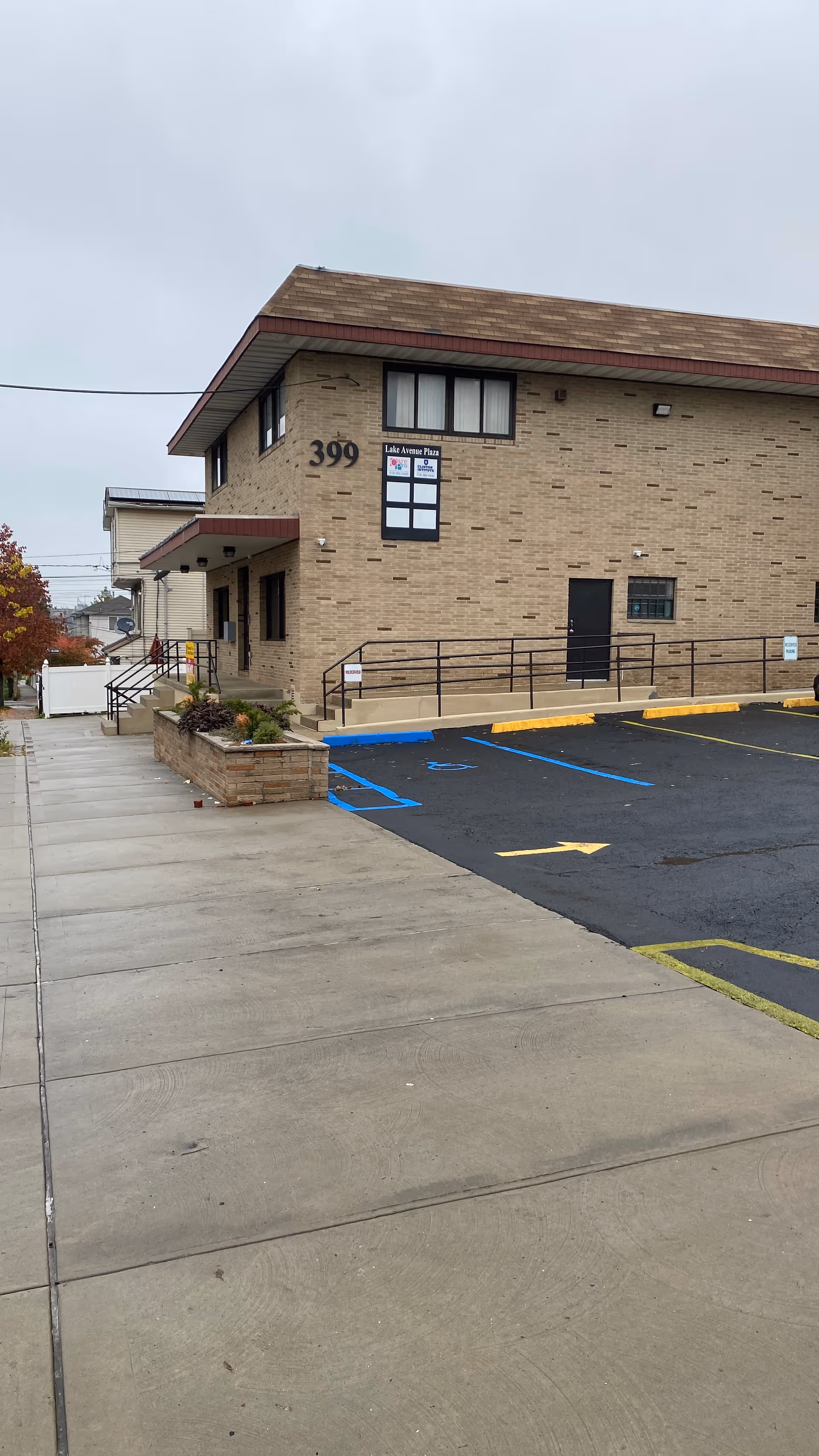 Brick senior living building with parking lot, handicap spaces, and ramp access.