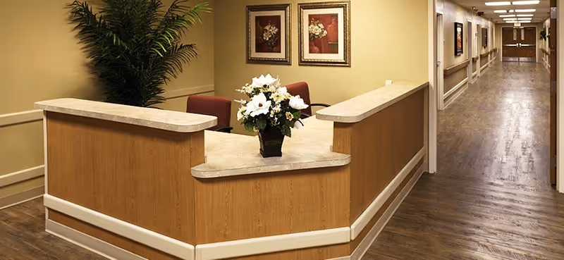 Reception desk in a warm hallway of a senior living center.