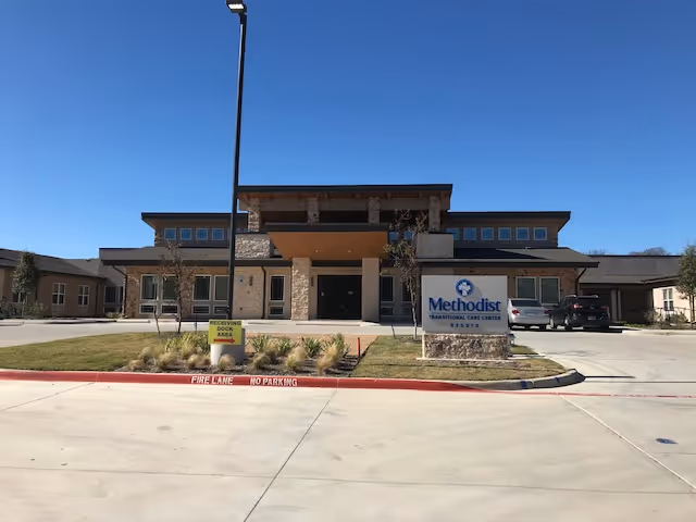 Exterior view of Methodist Transitional Care Center with entrance, sign, and parking.