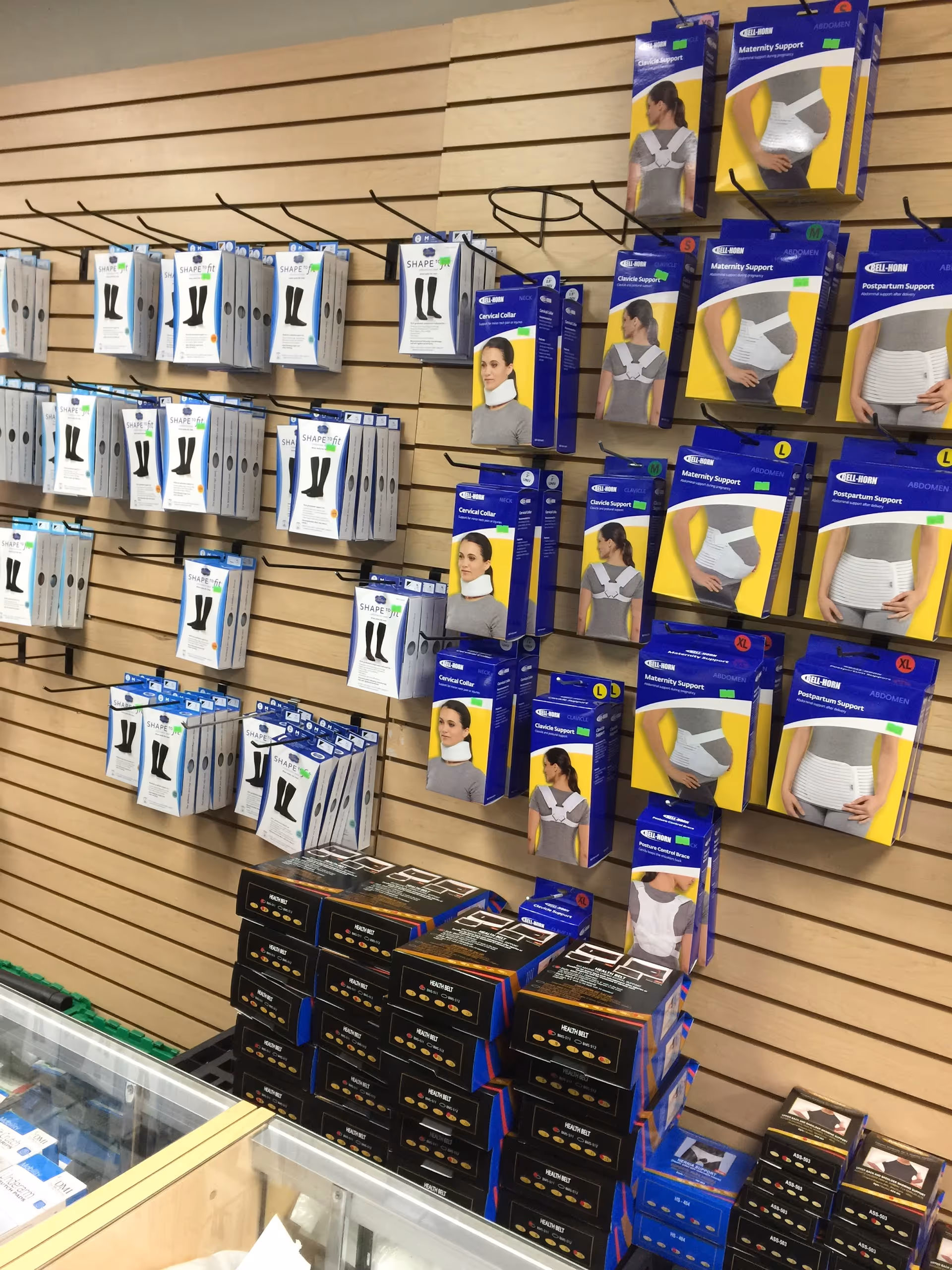 Rows of medical supply boxes displayed on a wooden slat wall inside a store.