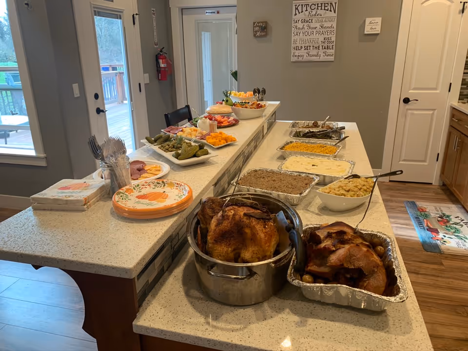 Buffet-style dining setup along a kitchen island with assorted dishes and roasted turkey.