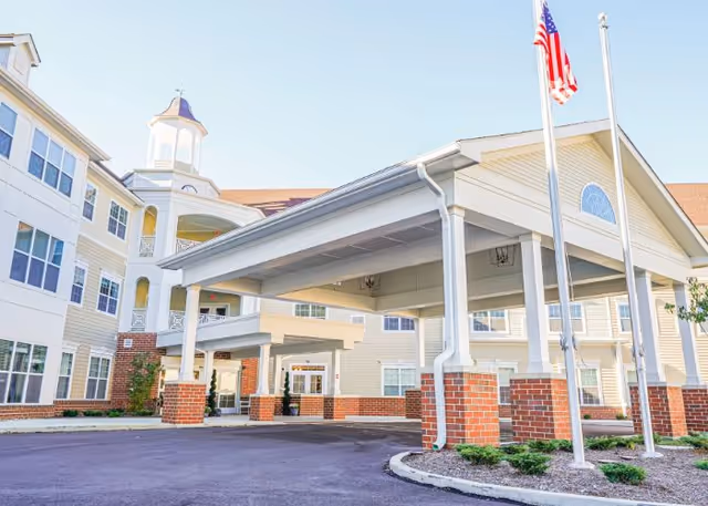 Exterior view of Harmony at Diamond Ridge with a covered entrance and flagpoles.