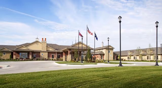 Front exterior view of Brookestone Home Health building with flagpoles and manicured lawn.