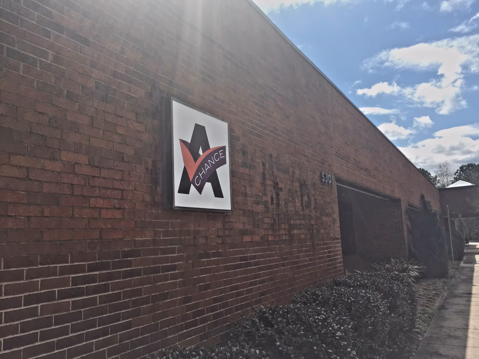 Brick exterior wall with a prominent 'Another Chance' sign and a sidewalk.