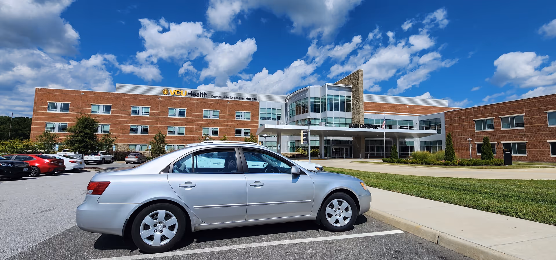 Front view of VCU Health Community Memorial Hospital with a parking lot and blue sky.