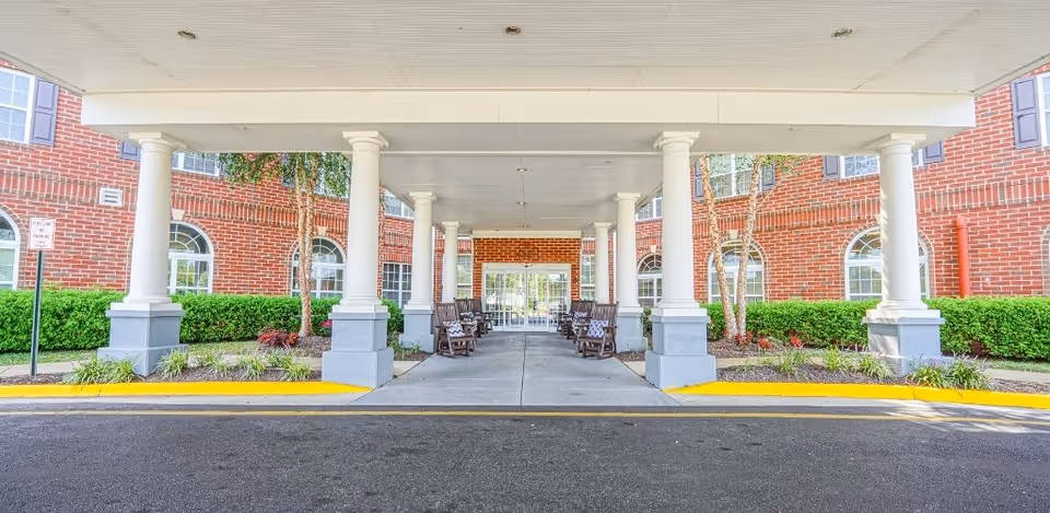 Covered entry with columns leads to a brick senior living facility.