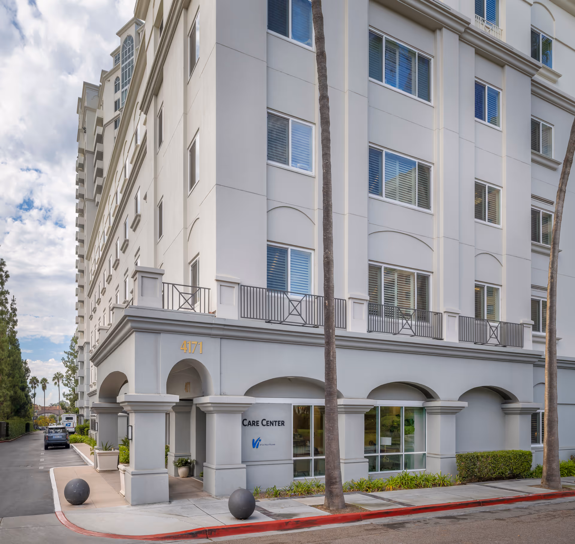 Tall white senior living building with arches and a street-side entrance labeled Care Center.