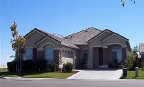 Exterior view of Safe and Loving Senior Care facility with driveway and manicured lawn.