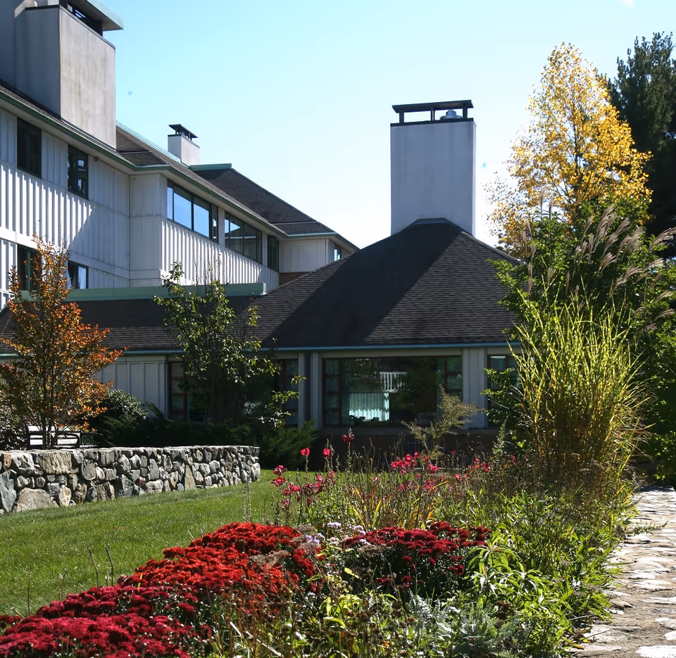 Exterior view of Orchard Cove building with a landscaped garden and stone wall.