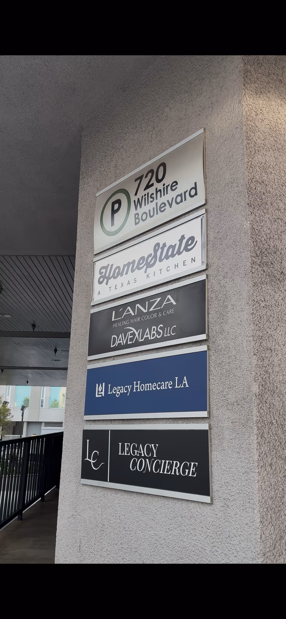 Exterior wall with stacked business signs including Legacy Homecare LA