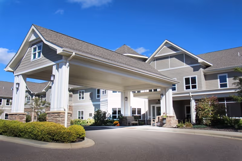 Exterior view of Deephaven Woods Senior Living facility with a covered entrance and drive.