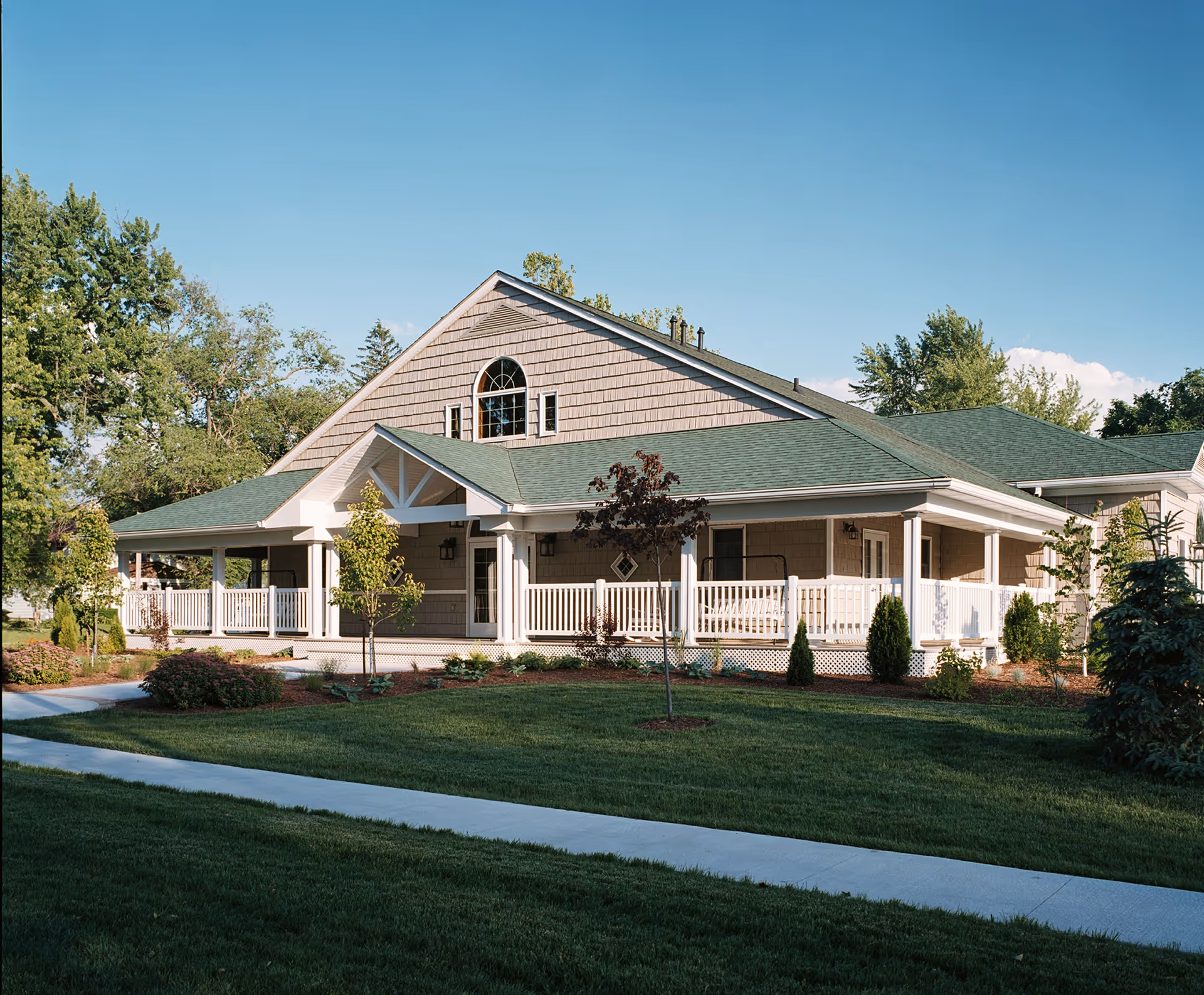 A single-story building with a wraparound porch and well-kept lawn.