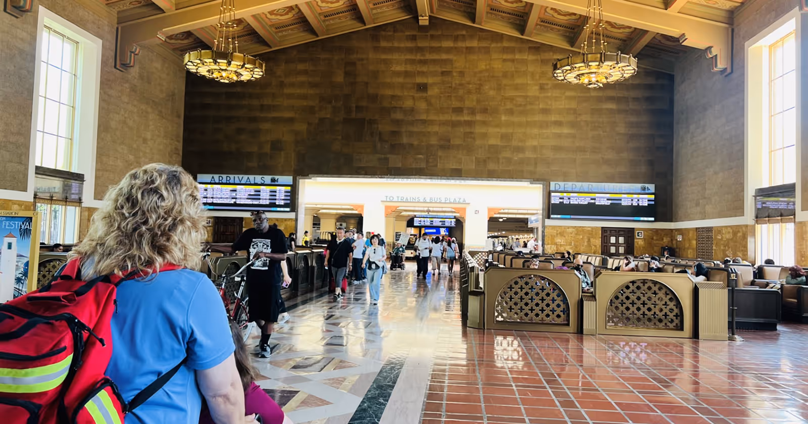 Spacious interior with check-in desks, seating, and travelers in a terminal.