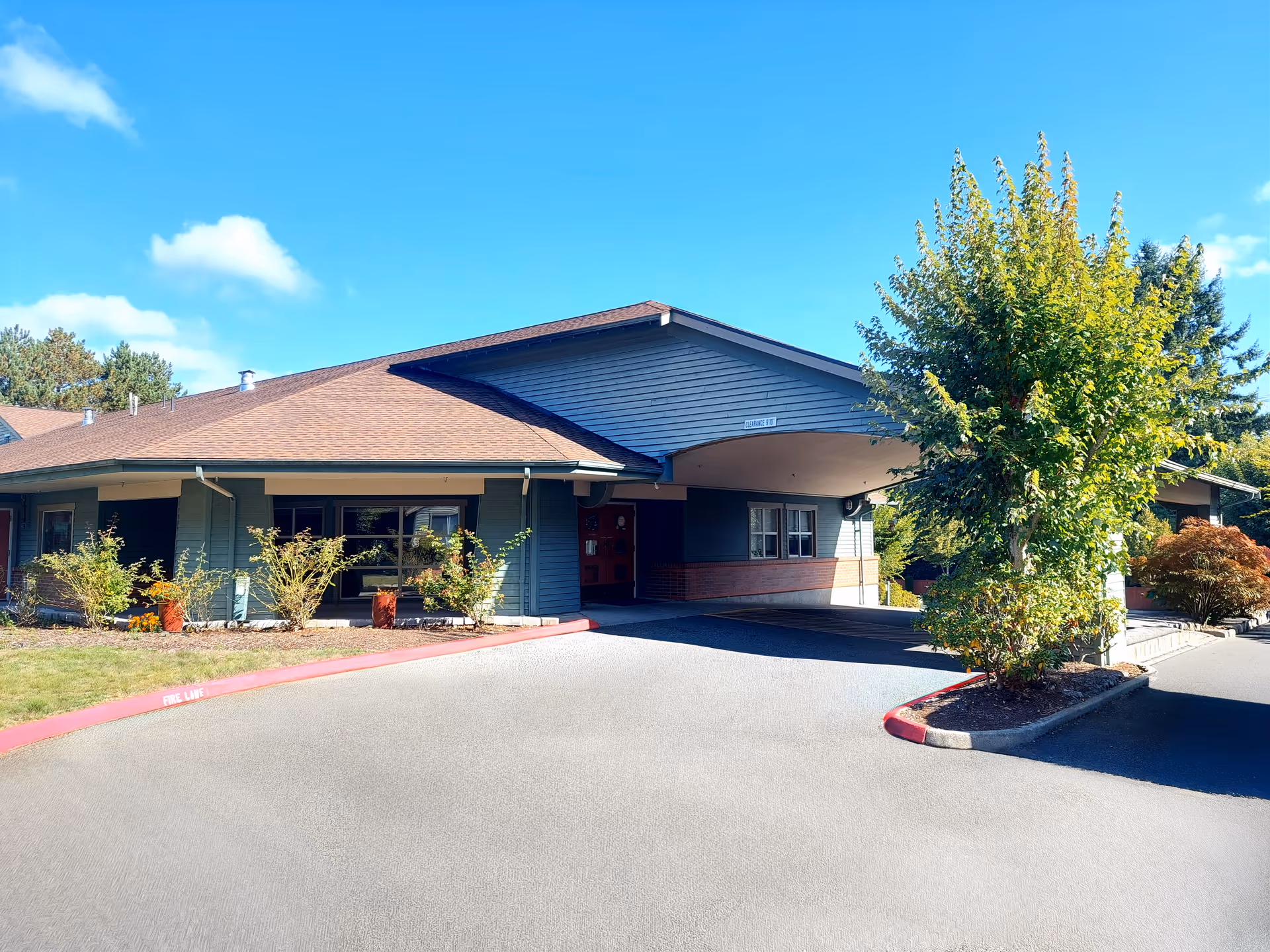 Exterior view of Agility Health and Rehabilitation facility with driveway, entrance, and trees.