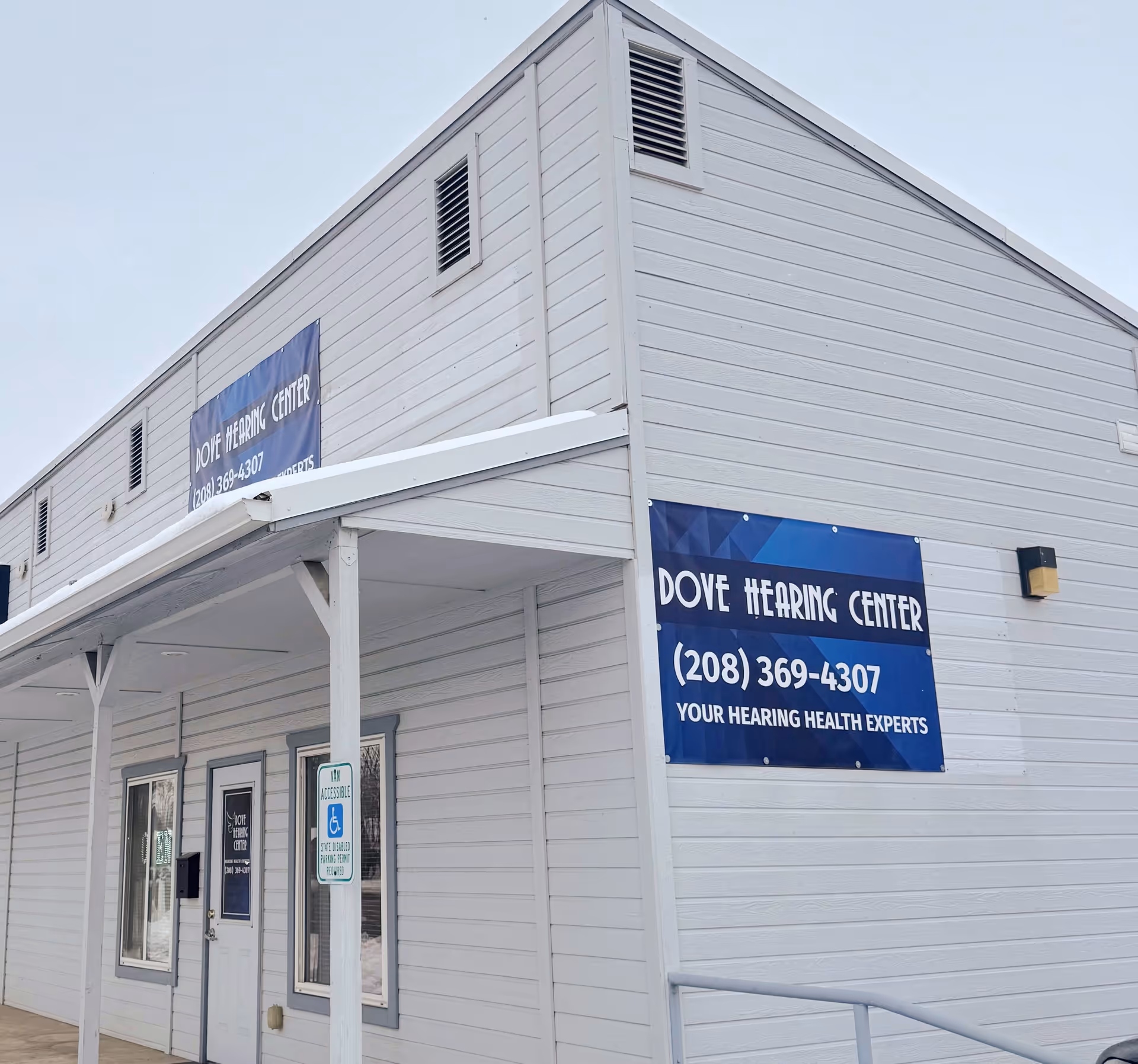 White exterior building with Dove Hearing Center banner and entrance doors.