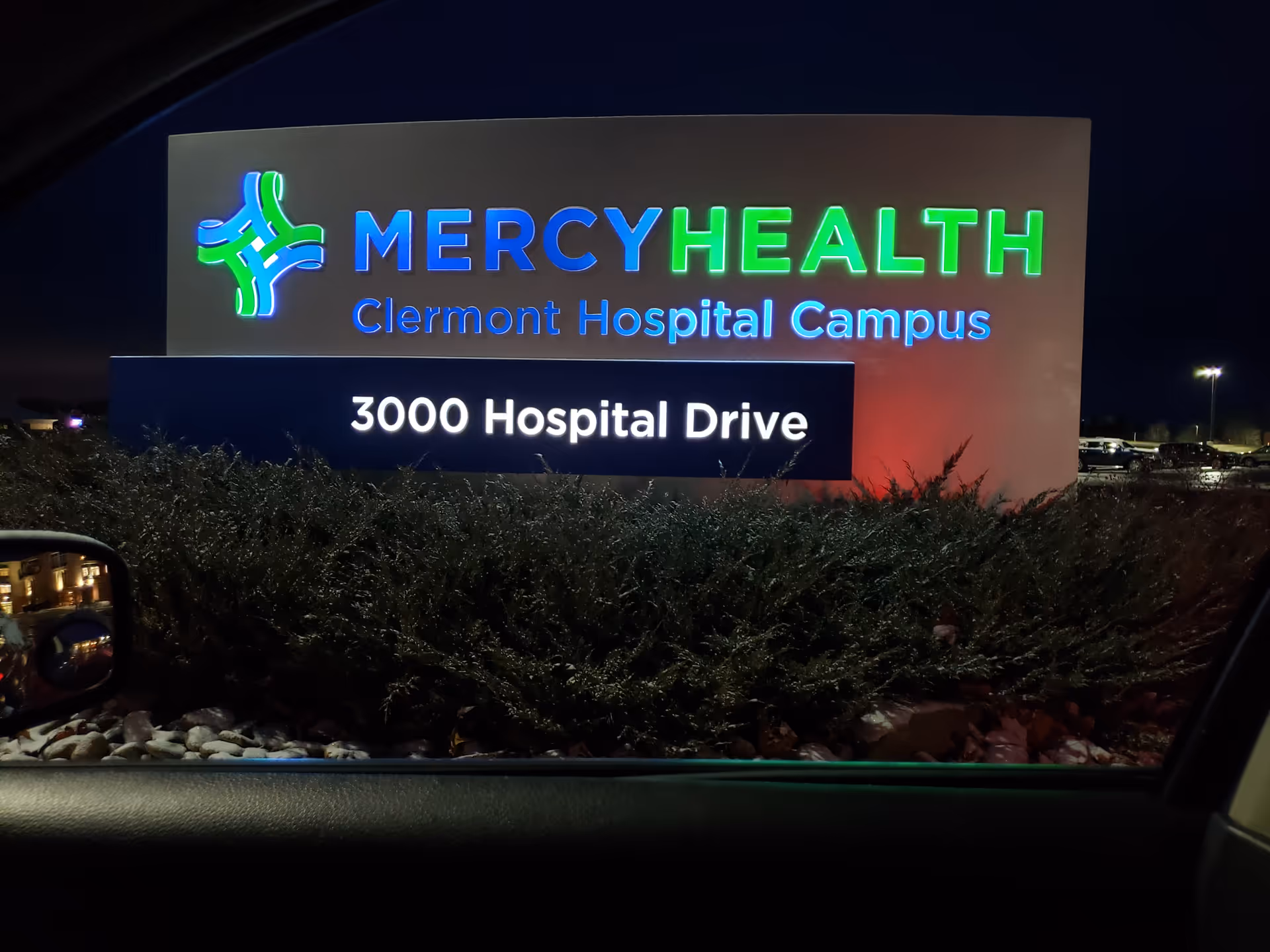 Illuminated Mercy Health sign displays Clermont Hospital Campus and 3000 Hospital Drive at night.