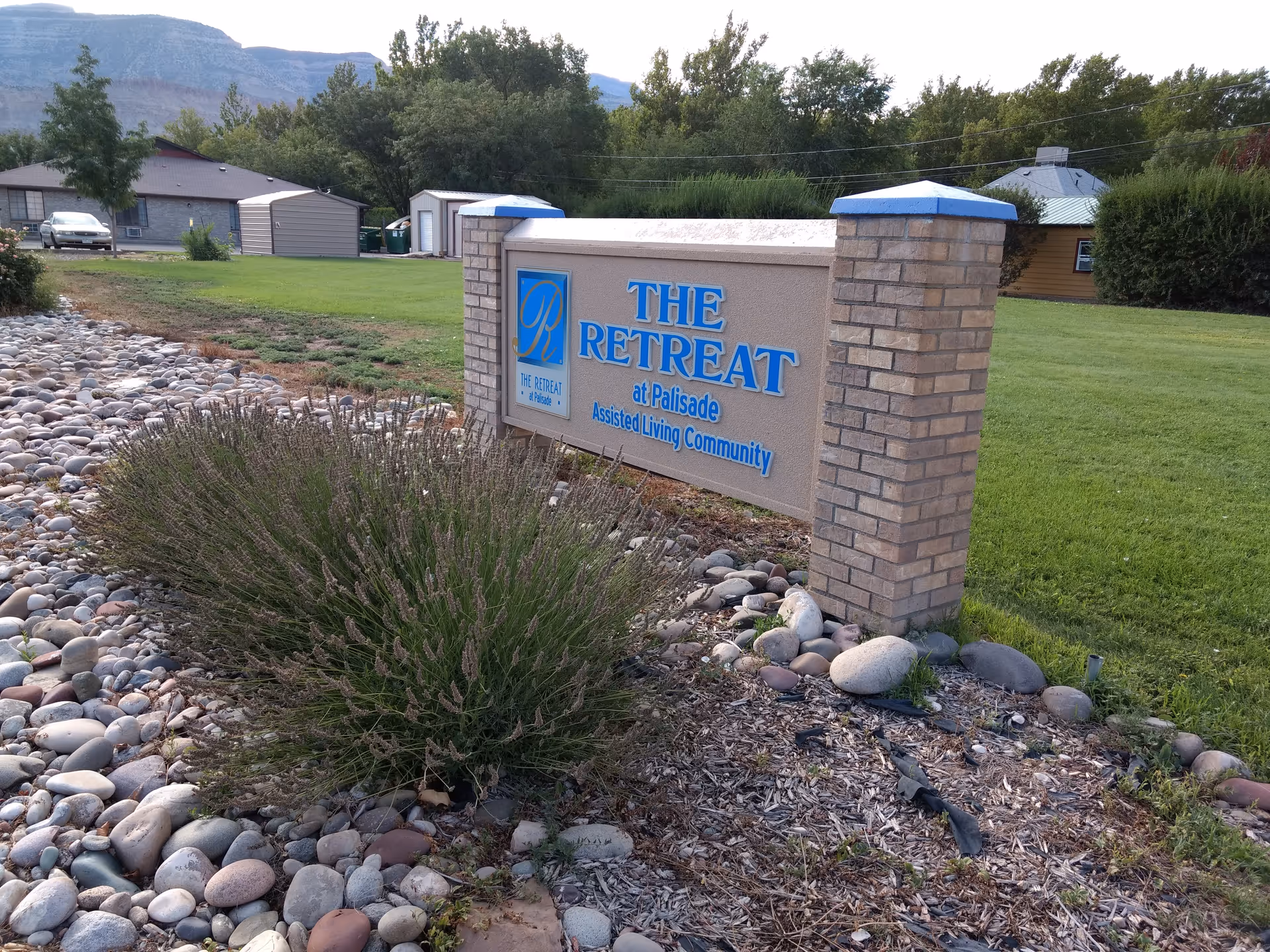 Outdoor sign for The Retreat at Palisade with brick pillars and rock landscaping