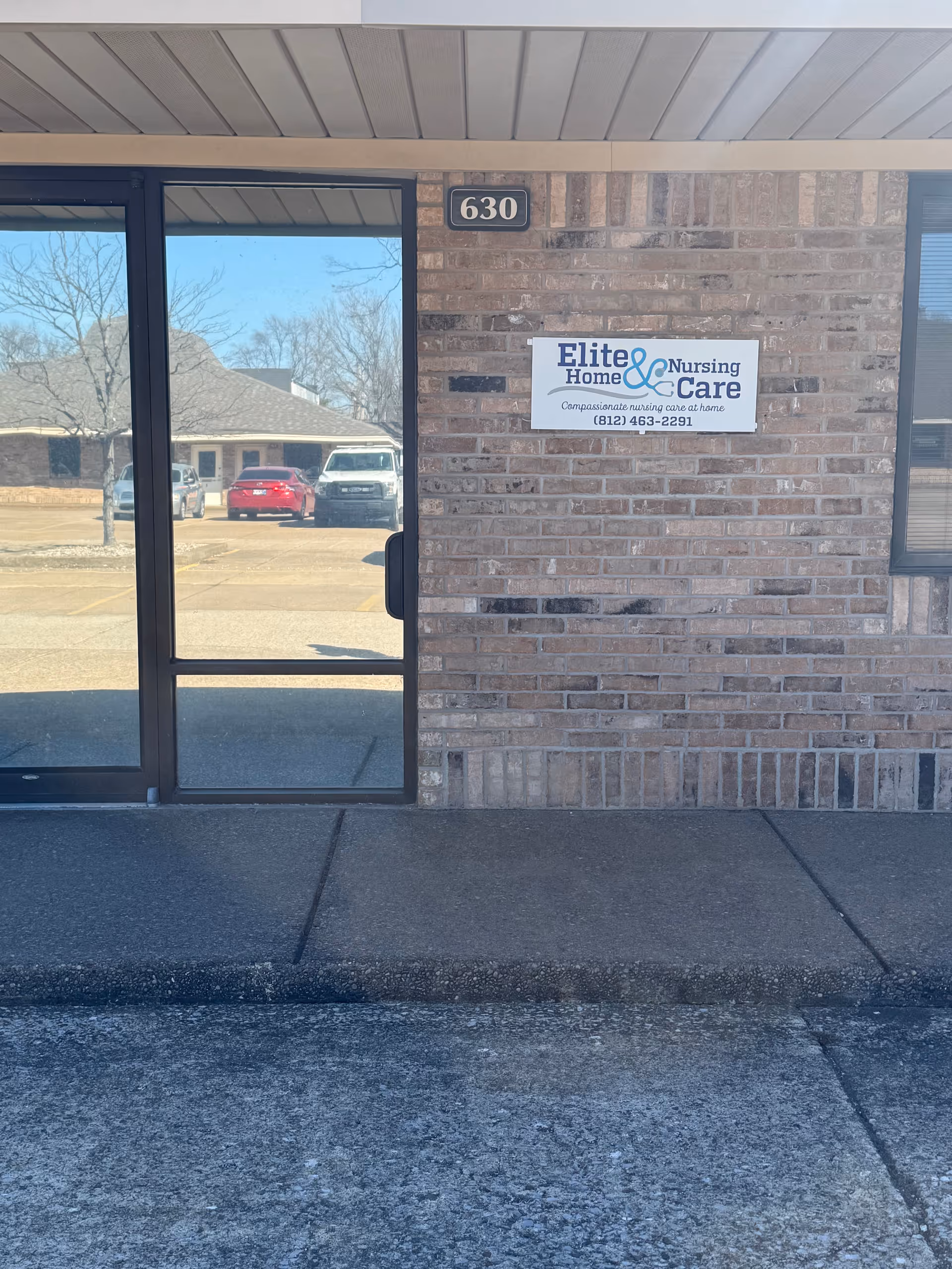 Exterior brick entrance of Elite Home & Nursing Care with a doorway and sign.
