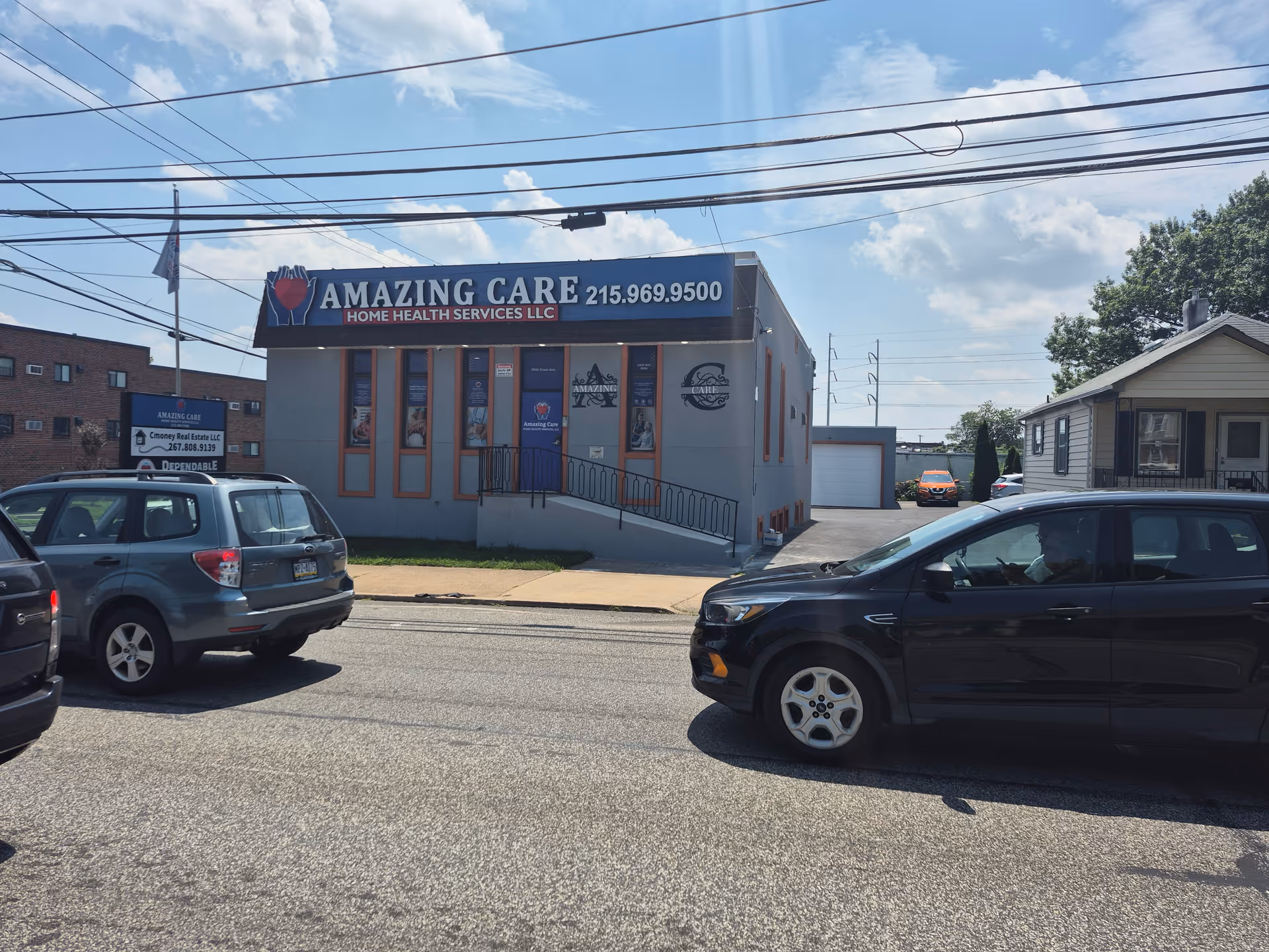 Two-story building with Amazing Care signage, parked cars, and overhead power lines.