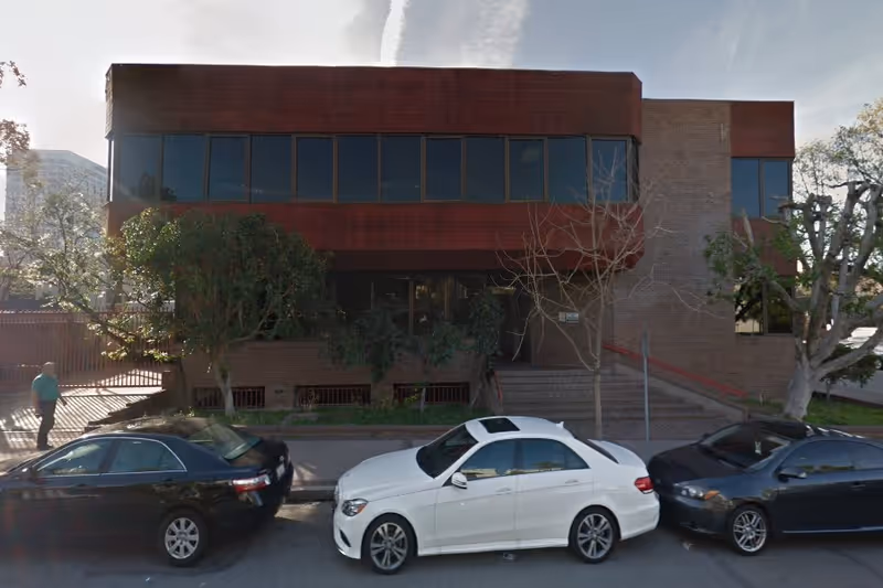Front exterior of Cypress Home Health Care, Inc., brick building with large windows and parked cars.