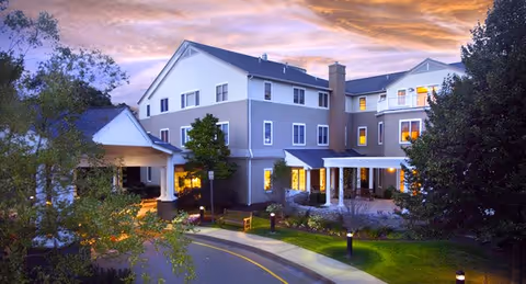 Exterior view of Maplewood at Orange, a multi-story senior living building, at dusk.