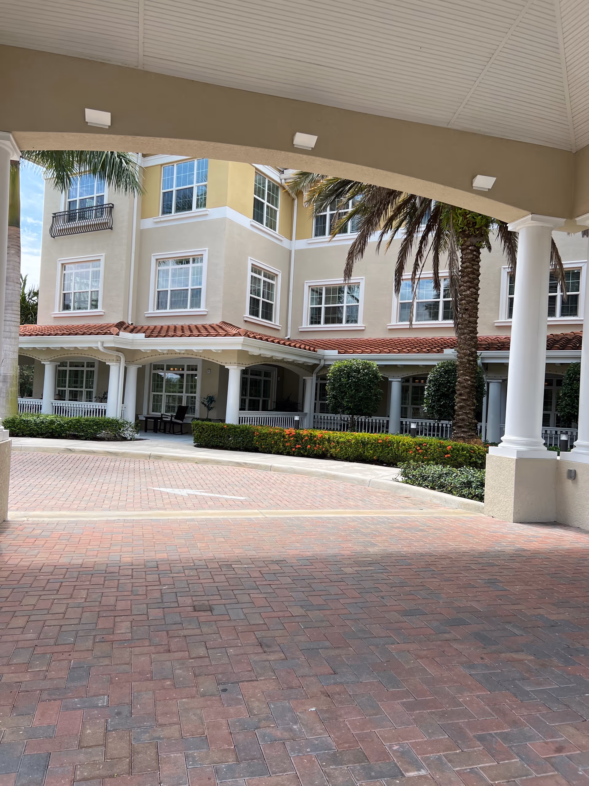 Exterior view of The Barclay at Boynton Beach with arches, columns, and palm trees.