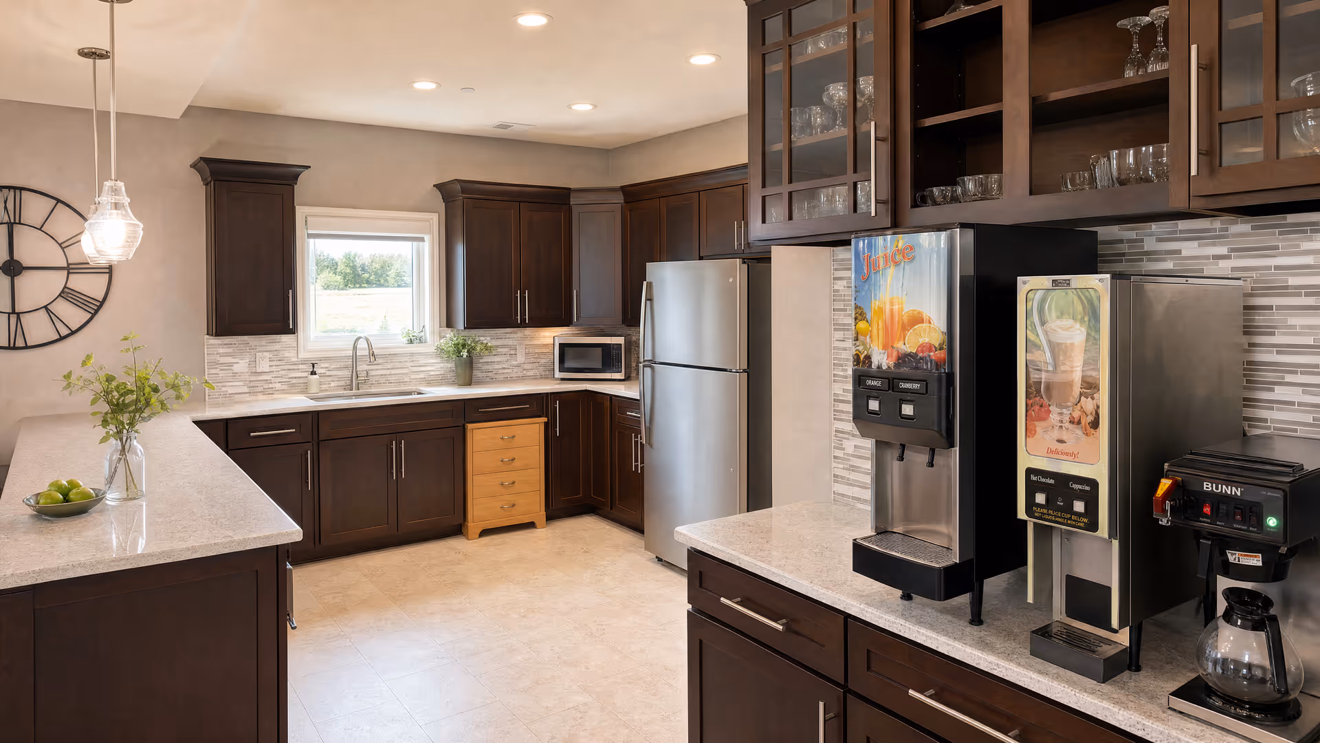 A dark wood kitchen with granite countertops, beverage station, and stainless appliances.