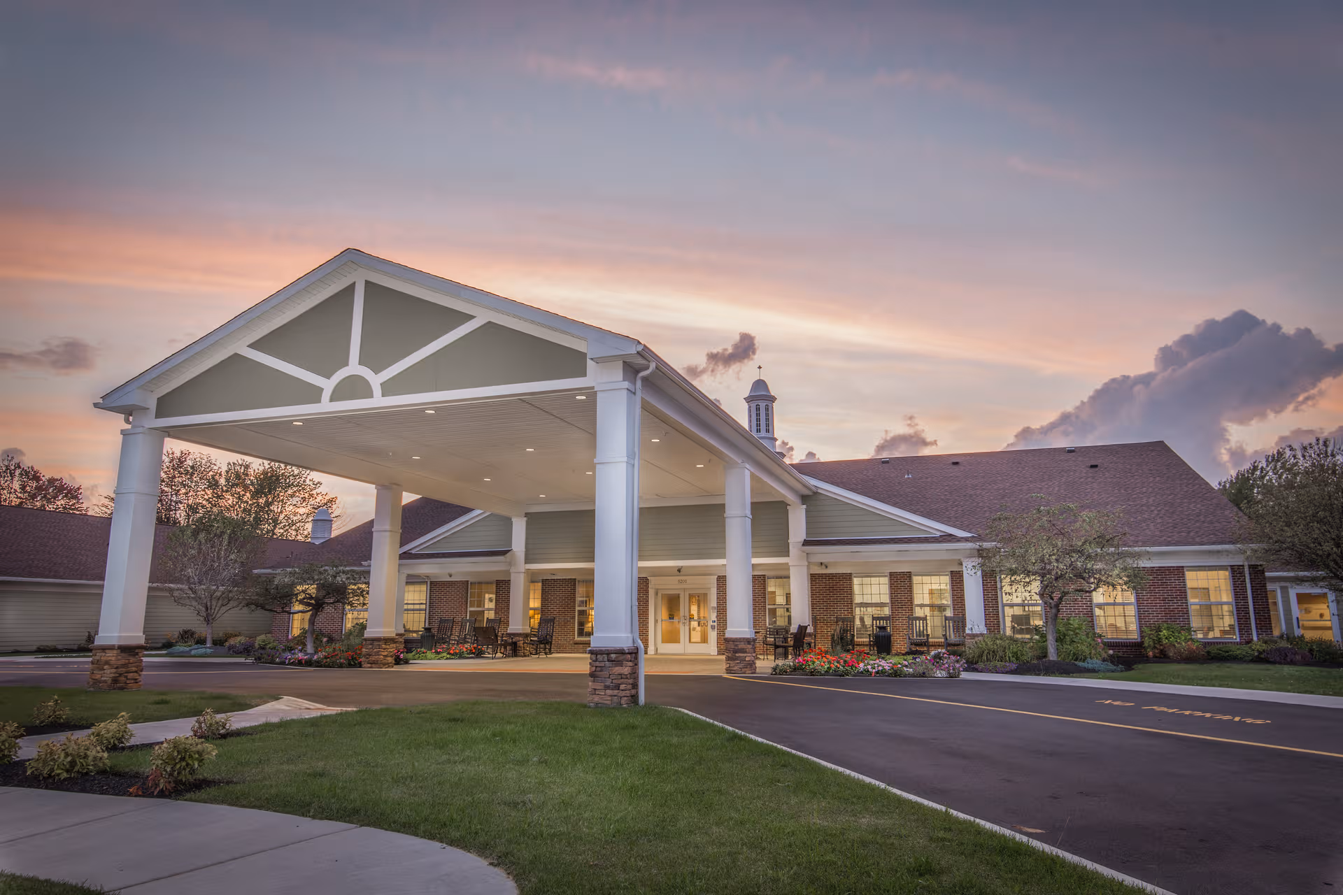 Front view of Orchard Heights senior living facility with a covered entrance at dusk.