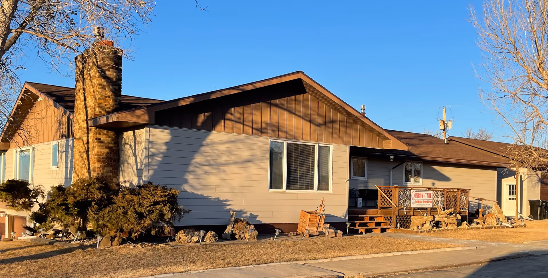 Exterior of Conroy Care Assisted Living, a single-story building with a wooden deck and sign.