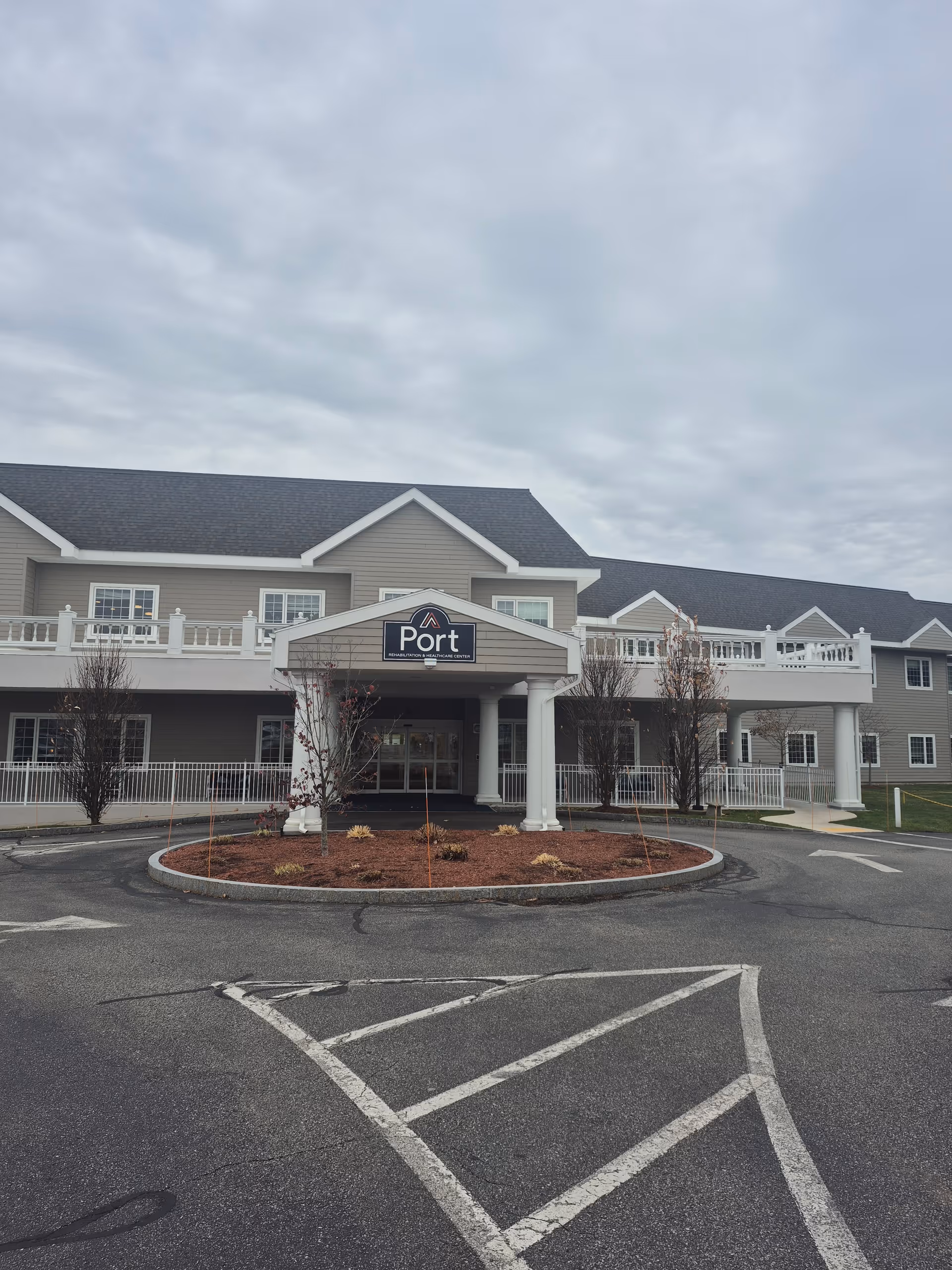 Front view of Port Healthcare Center building with circular landscaped island
