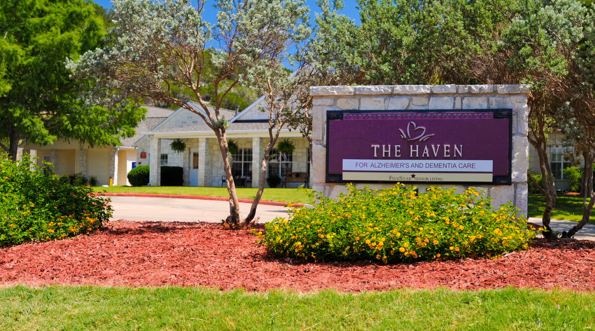 Front exterior of The Haven care facility with a purple sign and landscaping.
