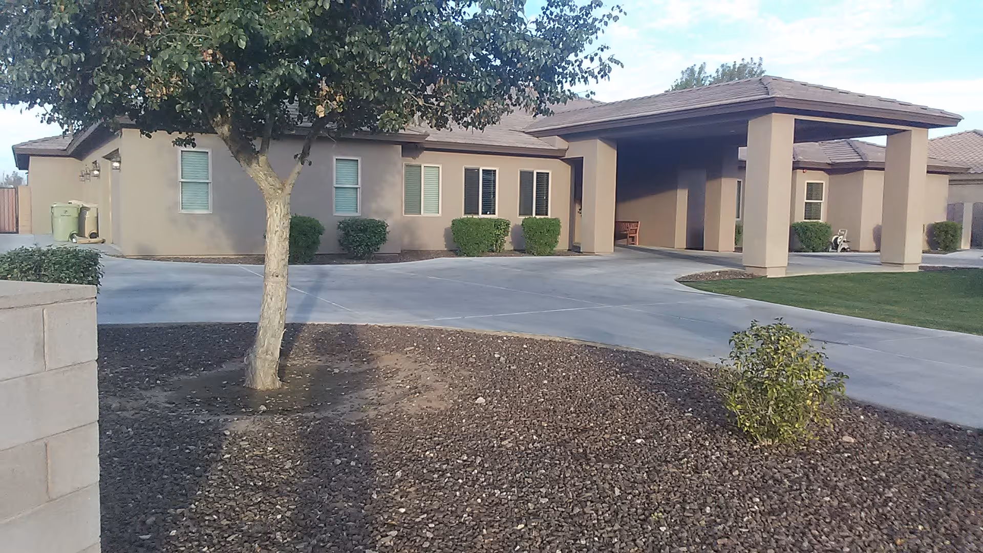 Exterior view of a single-story assisted living facility with a covered entrance.