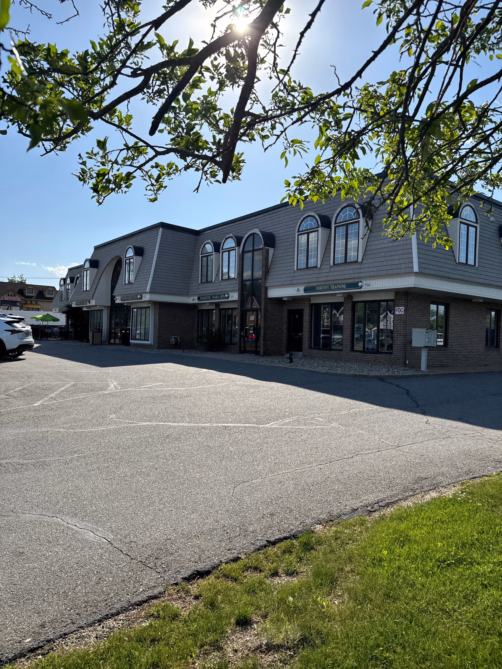 Exterior view of North Andover senior living center with arched windows and a parking lot.