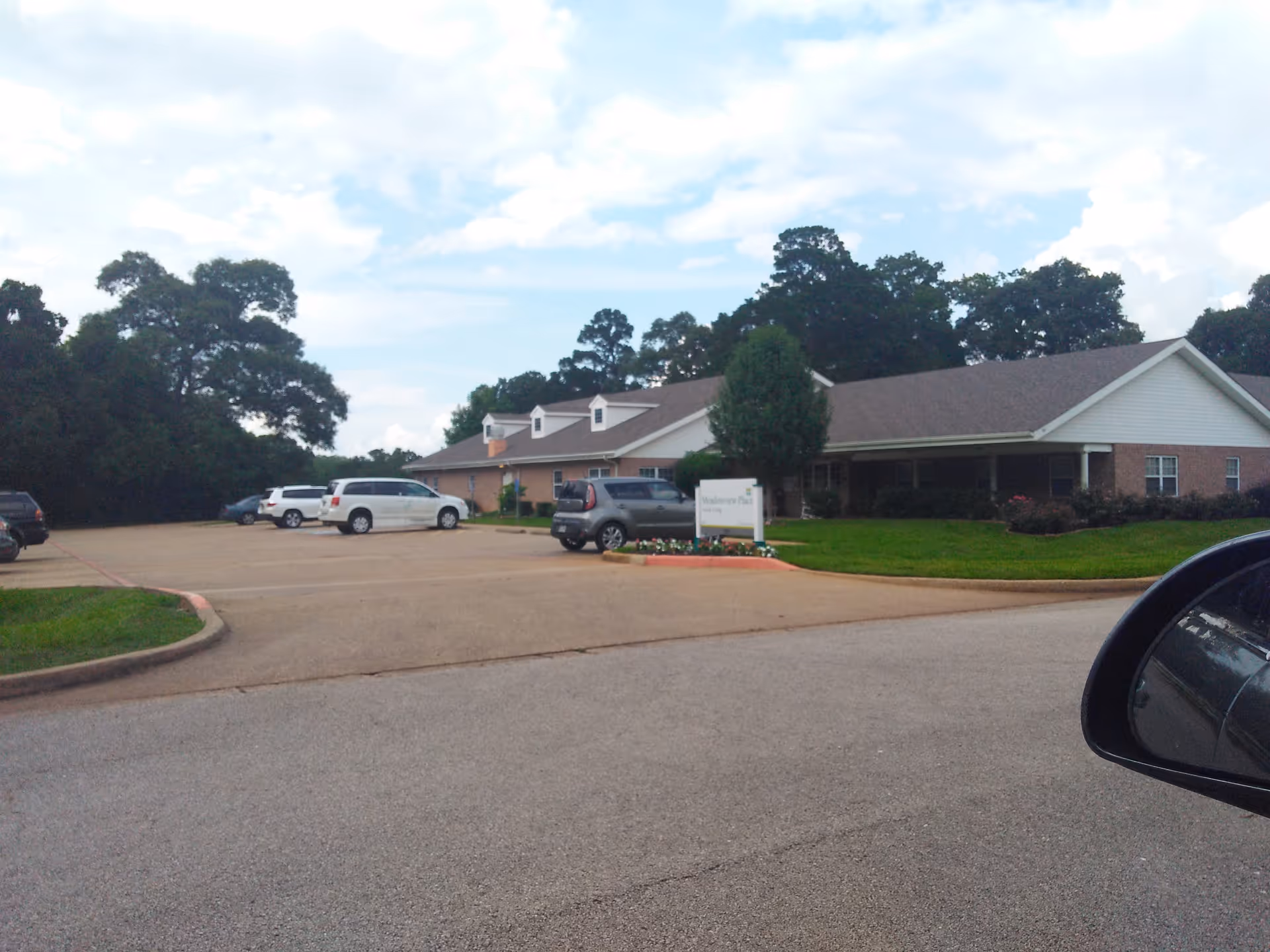 Front exterior of Meadowview Place senior living facility with parked cars.