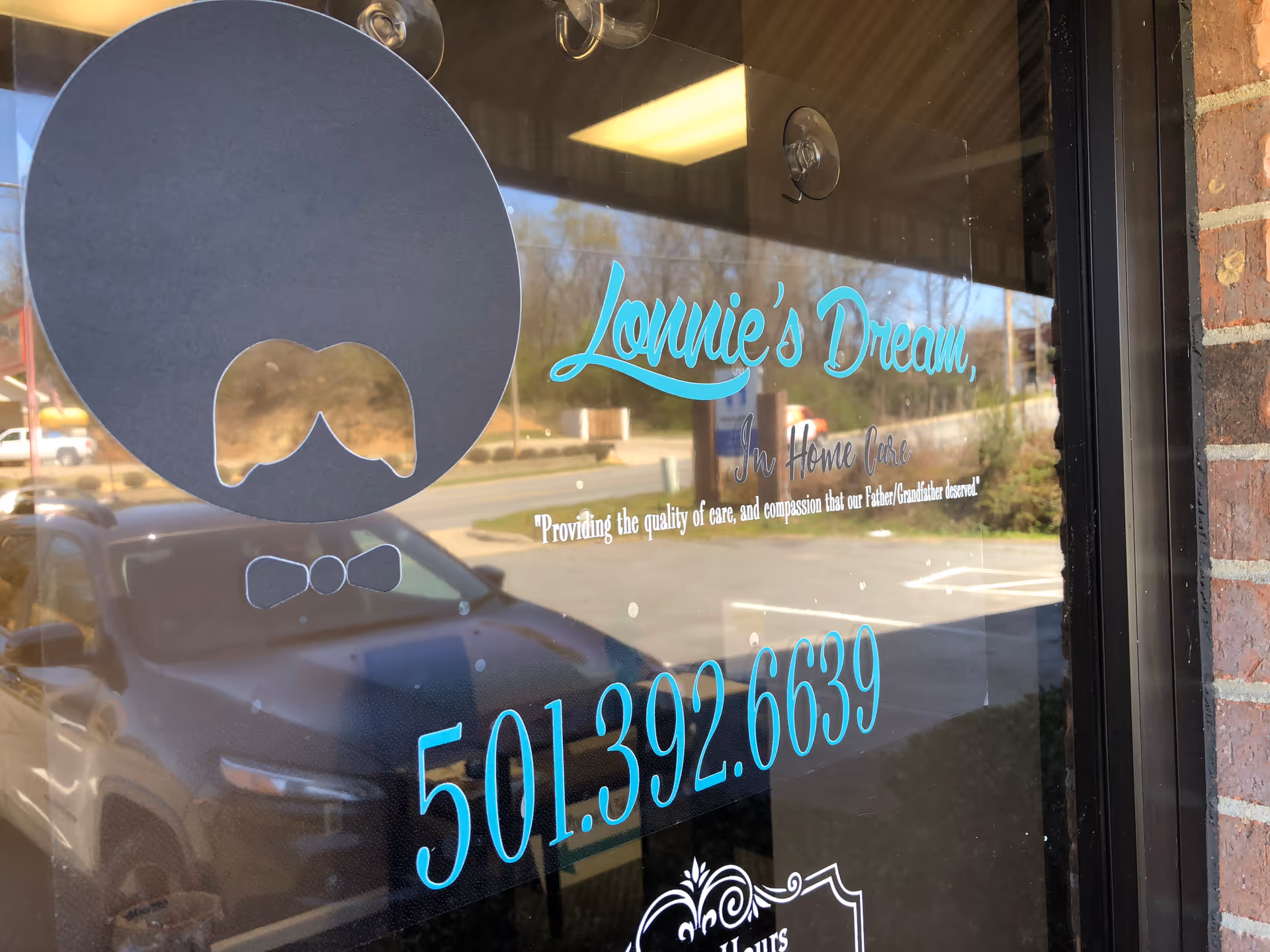 Glass storefront window displaying Lonnie's Dream in-home care sign and phone number.