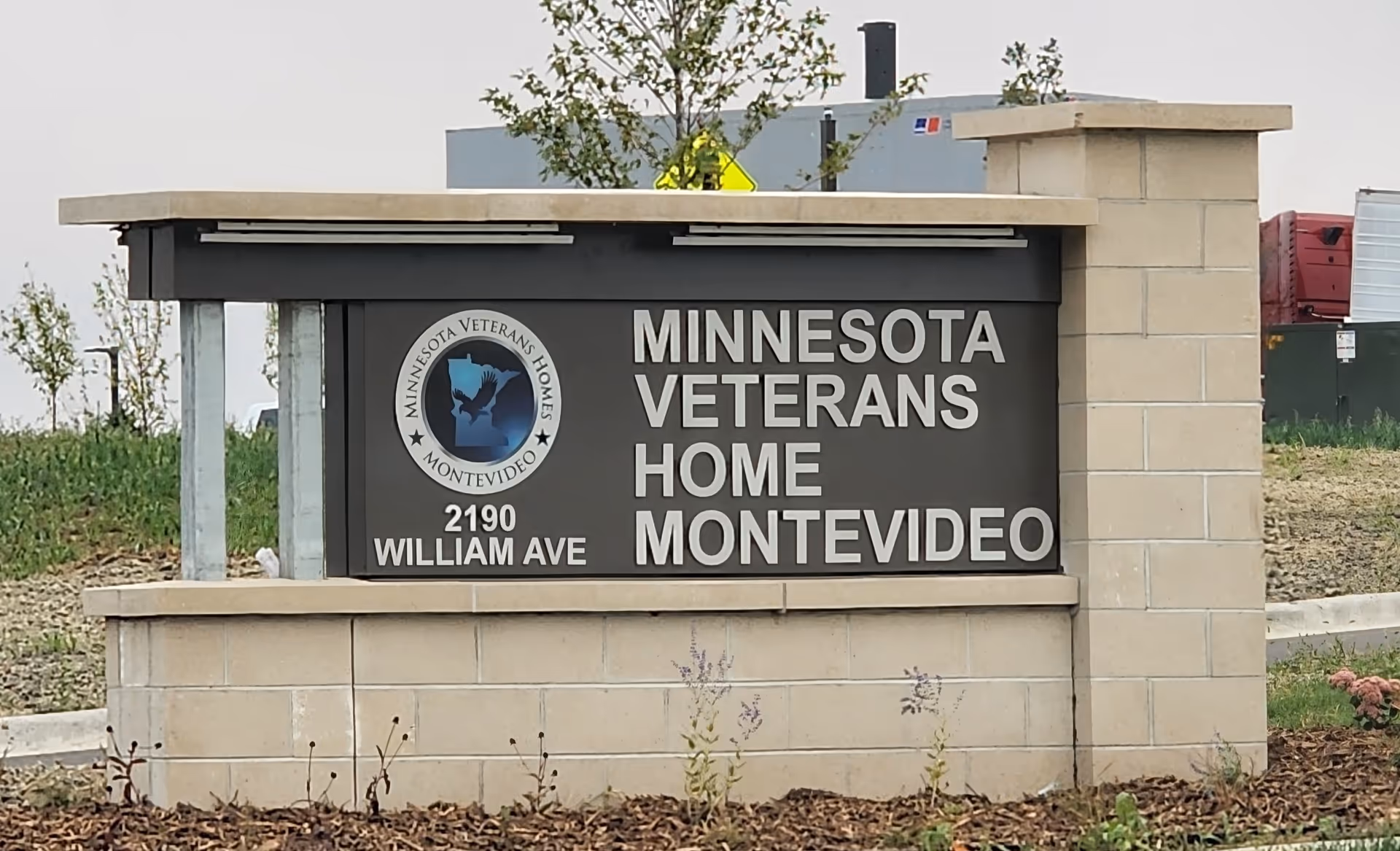 Outdoor sign with Minnesota Veterans Home Montevideo name and logo at facility entrance