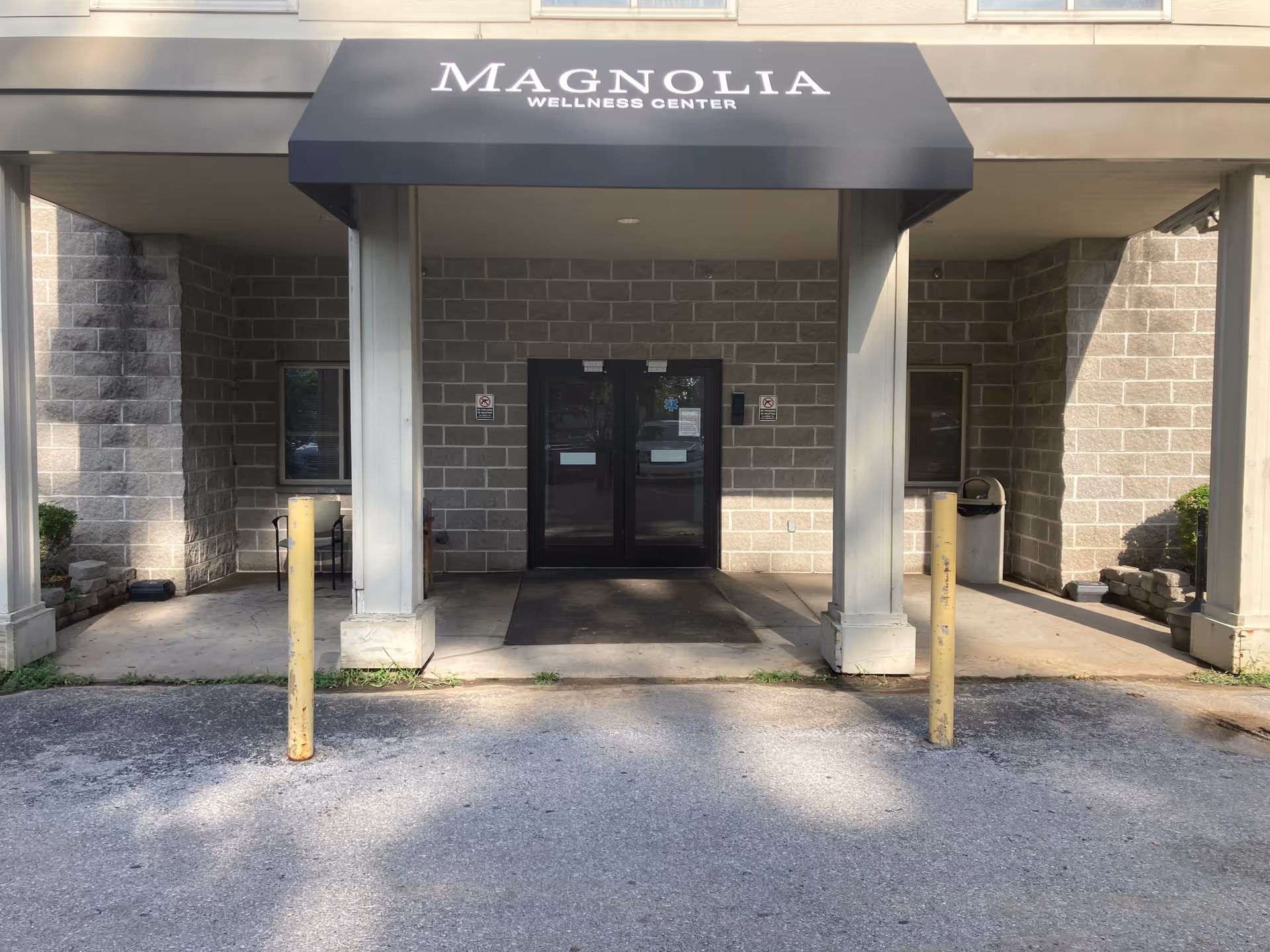 Exterior view of a building entrance with Magnolia Wellness Center canopy over double doors.